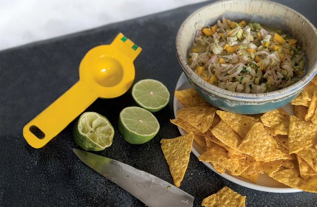 peruvian white fish ceviche in a ceramic bowl served with tortilla chips and fresh lime wedges